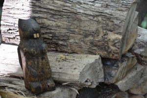 wooden beaver carving on woodpile
